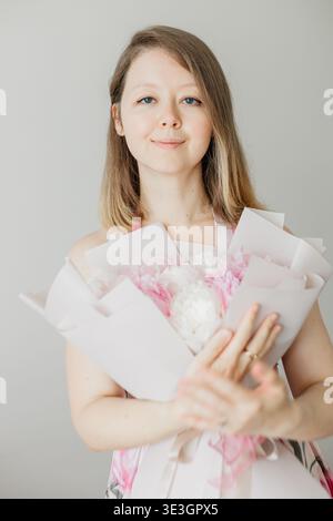 Junge Frau mit rosa und weißem Blumenstrauß Stockfoto