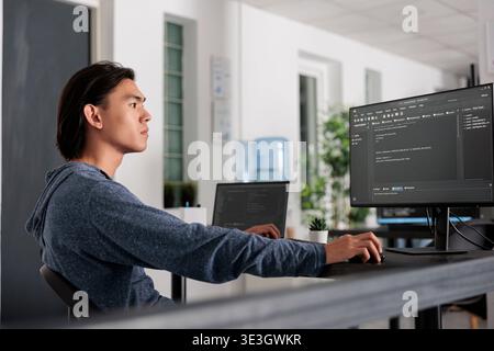 IT-Ingenieur schreibt mithilfe des Programmiercomputers HTML-Code in das Terminalfenster und erstellt eine neue Webschnittstelle am Schreibtisch. Systemalgorithmus für Programmierer und Analyse in Big-Data-Büros und IT-Servern. Stockfoto