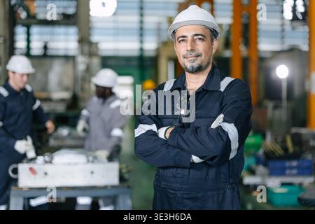 Erwachsener Reife Hispanic Latin Professional Engineer stehend im Fabrikporträt selbstbewusster Arm gefaltet Happy Lächeln aussehende Kamera Stockfoto