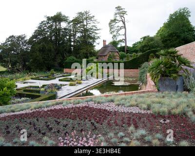 Blick über den restaurierten viktorianischen Duftgarten in Richtung Eines strohgedeckten Cottage im Newt Garden and Hotel, in der Nähe von Bruton, Somerset, England. Stockfoto