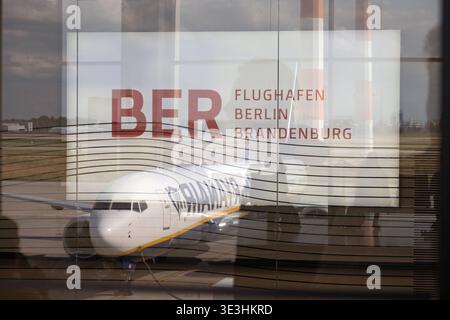 16.06.2025, Schönefeld, Brandenburg, DE - Flugzeug der Ryanair spiegelte sich am Flughafen BER in der Glasfassade des Terminals. Airline, Alltag, BER, Billigflieger, Billigfluggesellschaft, Brandenburg, Deutsch, Deutschland, Europa, europaeisch, Fernreise, Flieger, Fluggesellschaft, Flughafen Berlin Brandenburg, Fluglinie, Flugreise, Flugtechnik, Flugverkehr, Flugzeug, Glas, Glasfassade, innen, Innenaufnahme, Jahreszeit, Luftfahrt, Luftfahrtgesellschaft, Luftfahrtunternehmen, Luftverkehr, Passagierflugzeug, Passagiermaschine, QF, Querformat, Reflexion, Reise, Ryanair, Schild, Schönefeld, Som Stockfoto
