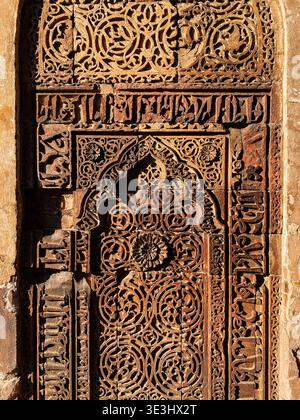 Komplizierte arabische Kalligraphie und geometrische Schnitzereien an der Steinmauer Stockfoto