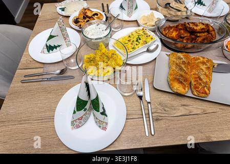 Festlicher Tisch mit Pierogi, Fischfilet, Kartoffeln und anderen traditionellen polnischen Gerichten Stockfoto