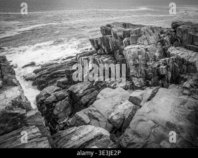 Bailey Island, Maine, Giant Steps - dramatisches Schwarzweiß-Foto einer zerklüfteten felsigen Küste mit mehrschichtigen Klippen und stürzenden Meereswellen, EM Stockfoto