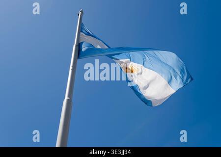 Blick auf die große argentinische Flagge, die in den Wind fliegt, auf dem de Mayo-Platz in argentinischer Hauptstadt, aufgenommen im hellen Sommerlicht in Buenos Aires, Argentin Stockfoto