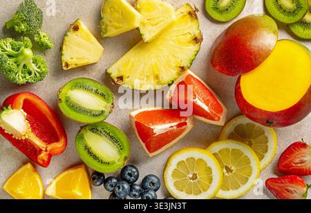 Top View Sortiment an Vitamin-C-reichem Obst und Gemüse einschließlich Kiwi, Mango, Ananas, Grapefruit, Zitrone, Erdbeeren, Heidelbeeren, Orange, Re Stockfoto