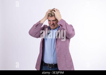 Gestresster Mann, der den Kopf in den Händen hält, auf weißem Hintergrund Stockfoto