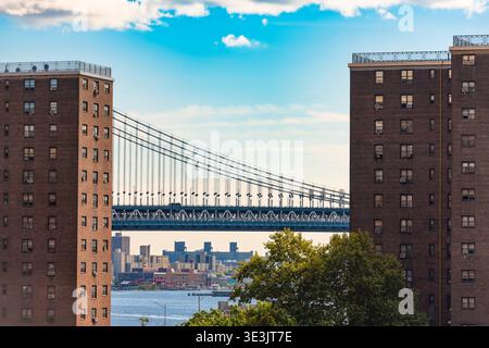 Die blaue Stahlkonstruktion der Manhattan Bridge ist zwischen zwei hohen Backsteingebäuden in New York City eingerahmt. Stockfoto