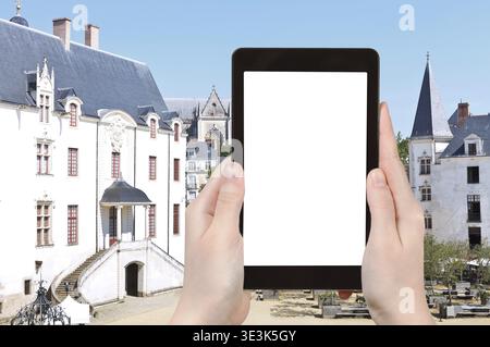 Reisekonzept Touristenfoto im Innenhof des Schlosses der Herzöge der Bretagne in Nantes, Frankreich, auf Tablet-PC mit ausgeschnittenem Bildschirm mit leerem Bild Stockfoto
