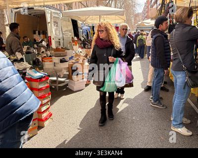 Porta Portese Flohmarkt. Rom, Italien. Shopper stöbern an Verkaufsständen im Freien und verkaufen verschiedene Schuhe, darunter Turnschuhe und Stiefel, die auf Boxen ausgestellt sind. Stockfoto