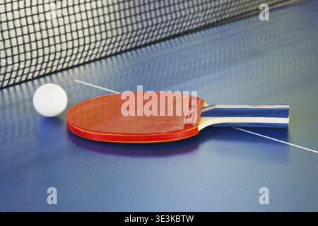 Rotes Paddle, Tennisball auf Tischtennistisch aus nächster Nähe Stockfoto