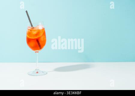 Aperol Spritz, traditioneller Sommercocktail auf blauem Hintergrund mit sonnigem Schatten. Stockfoto