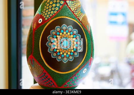 Ein Nahaufnahme eines großen dekorativen Eies mit aufwendigen handgemalten Punktbildern im Aborigine-Stil. Das Ei zeigt einen zentralen Kreis Stockfoto