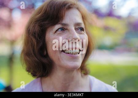 Schöne ältere Frau draußen im Frühling Natur stehen. Kopierbereich. Stockfoto