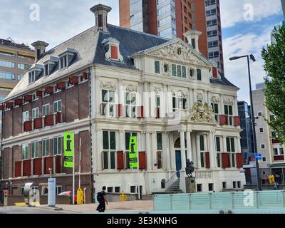 Ein historisches barockes Gebäude mit weißer, verzierter Fassade und roten Backsteinfassaden mit roten Fensterläden, das sich in einer städtischen Umgebung befindet Stockfoto