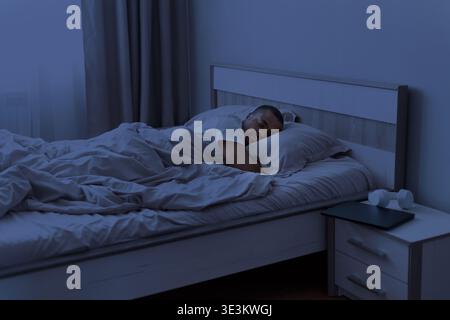 Junger afroamerikaner, der nachts friedlich im Bett schläft Stockfoto