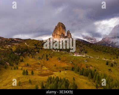 Majestätisch erheben sich die zerklüfteten Gipfel der Cinque Torri inmitten einer grünen Landschaft unter einem wilden Himmel, Cortina d'Ampezzo, Venetien, Italien. Stockfoto