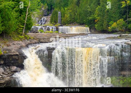Ein gestufter Wasserfall an den Trenton Falls in New York, der vom West Canada Creek stammt und über geschichtete Felsformationen kaskadiert und von dichtem Wald umgeben ist Stockfoto