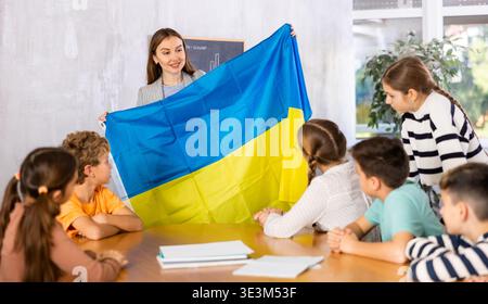 Lehrer zeigt ukrainische Flagge einer Gruppe von Schulkindern Stockfoto