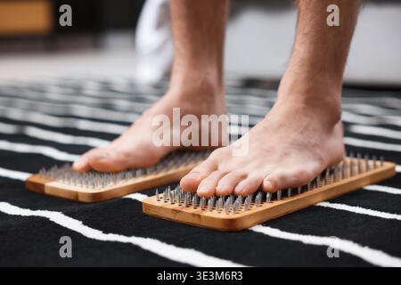 Mann, der zu Hause auf Sadhu-Brettern steht, Nahaufnahme Stockfoto