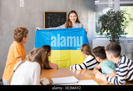 Lehrer zeigt ukrainische Flagge einer Gruppe von Schulkindern Stockfoto