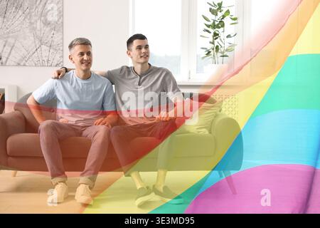 Glückliche schwule Paar auf dem Sofa zu Hause sitzen Stockfoto