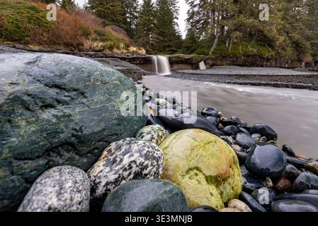 Bunte Steine und Wasserfall am Sandcut Beach - Jordan River Regional Park - in der Nähe von Sooke, Vancouver Island, British Columbia, Kanada Stockfoto