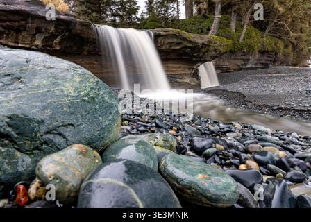 Bunte Steine und Wasserfall am Sandcut Beach - Jordan River Regional Park - in der Nähe von Sooke, Vancouver Island, British Columbia, Kanada Stockfoto