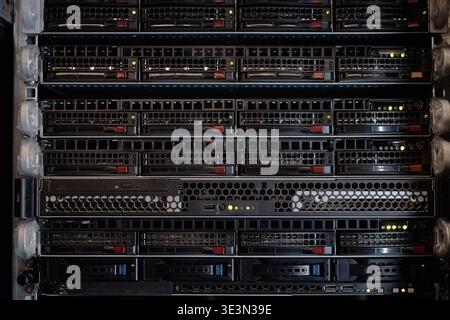 Nahaufnahme des Server-Racks mit mehreren Festplatten, die im Rechenzentrum betrieben werden Stockfoto