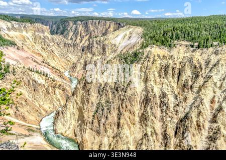 Ein Fluss fließt durch einen Canyon mit einem Berg im Hintergrund. Das Wasser ist klar und der Berg ist mit Bäumen bedeckt Stockfoto