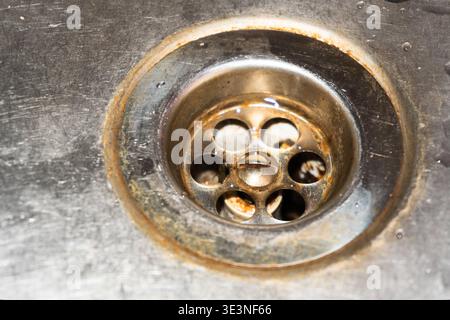 Alte Abflüsse im Waschbecken, rostiger Abfluss in einem Metallwaschbecken, kaputtes Waschbecken, kaputter Abfluss in der Wohnung, steigende Kosten für die Versorgung, Wasser sparen, alte Wohnung renoviert Stockfoto