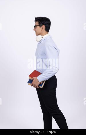 Mann in Geschäftskleidung, der ein rotes Buch im Studio hält Stockfoto
