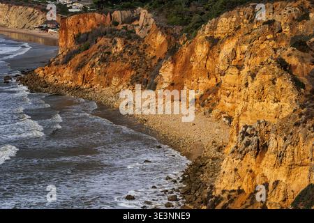 Küste der Algarve mit abgeschiedenem Kiesstrand unter hohen Klippen am Atlantischen Ozean in Lagos, Süd-Portugal. Stockfoto