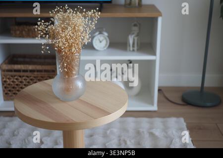 Holztisch mit Blumenvase in moderner Wohnzimmereinrichtung Stockfoto