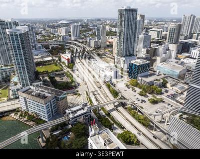Aus der Vogelperspektive einer Stadt mit Wolkenkratzern, Autobahnen und Bahngleisen, die durch die urbane Landschaft führen, Brickell, Miami, Florida, USA. Stockfoto