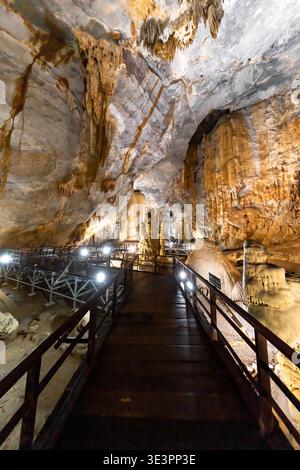 Blick auf einen hölzernen Fußweg, der durch das riesige, höhlenartige Innere der Paradise Cave führt und dramatische Felsformationen und Strukturen enthüllt, Paradise Cave Stockfoto