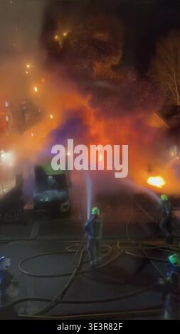 Screenshot aus dem Video der PA vom 23./03/26, in dem Feuerwehrleute eine Flamme in der Highfield Road, Golders Green, London, angriffen, nachdem am Montag ein offensichtlicher Brandanschlag auf vier Krankenwagen des Jewish Community Ambulance Service in London verübt wurde. Ausgabedatum: Dienstag, 24. März 2026. Stockfoto