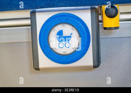 Ein blaues Kinderwagen-Symbol auf einer Fußgängerüberquerung, das Eltern mit Kinderwagen bei sicheren Straßenüberquerungen hilft. Stockfoto