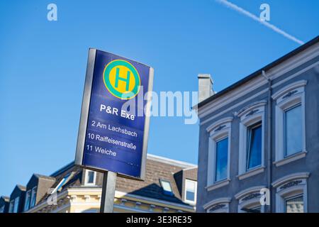 Flensburg Bushaltestelle Schild mit Streckeninformationen vor einem hellblauen Himmel mit Wohngebäuden im Hintergrund an einem sonnigen Tag. Stockfoto