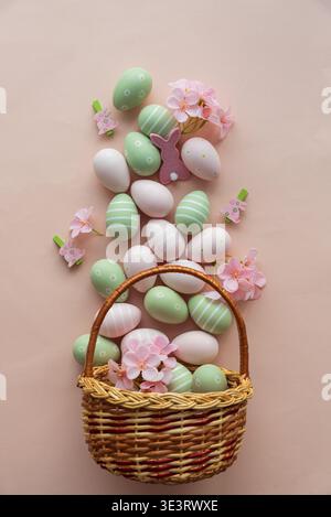 Osterkorb mit Pasteleiern, Blumen und Häschen Deko. Festliche Frühlingsflachung Stockfoto