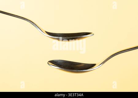 Zwei leere Löffel auf gelbem Hintergrund für Design Stockfoto