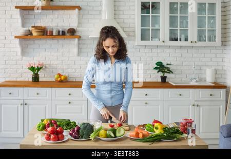 Frau hackt Gemüse für Salat zu Hause Stockfoto