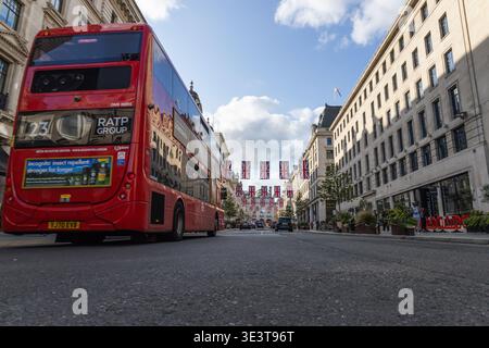 Flacher Blick auf einen roten Bus auf einer Londoner Straße mit Flaggen. London, UK, 23. Juli 2023 Stockfoto