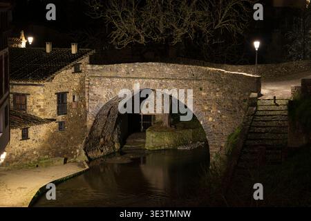 Nächtlicher Blick auf die La Carcel Brücke, eine alte Steinbrücke in der historischen Altstadt von Potes Cantabria Spanien Stockfoto