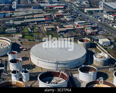 Aus der Vogelperspektive der Industrietanks, die unter dem Sonnenlicht leuchten und den Himmel über dem weitläufigen Industriegebiet spiegeln, Kalochori, Thessaloniki, Griechenland. Stockfoto