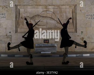 Zeremonielle griechische Evzones-Wachen marschieren nachts am Grab des unbekannten Soldaten auf dem Syntagma-Platz in Athen, Griechenland Stockfoto