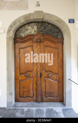Kunstvoll geschnitzte barocke Holztür in einem Steinbogenportal in der Altstadt von Lindau, Bayern, Deutschland Stockfoto