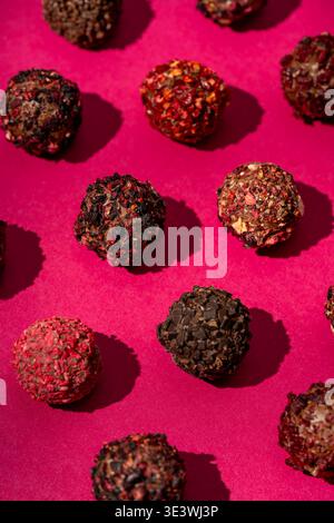 Lassen Sie sich vom künstlerischen Charme handgemachter Schokoladentrüffel mit lebendigen getrockneten Beeren und Früchten verwöhnen, die eine köstliche Mischung aus Aromen und Früchten bieten Stockfoto