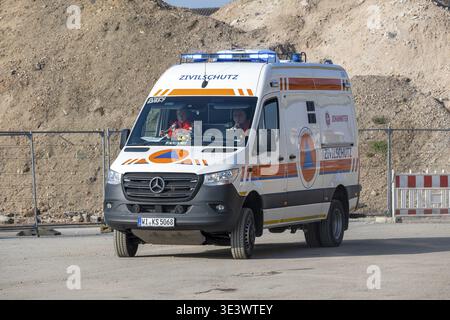 Auf einer Baustelle neben Sandstapeln und Sperrzäunen steht ein Notarztwagen Stockfoto