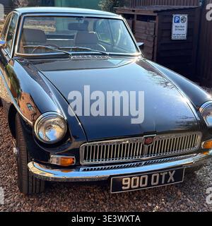 1974 MGB GT parken neben dem humorvollen MG-Parkschild, das den Stolz des britischen Oldtimers und die Kultur der Enthusiasten unterstreicht Stockfoto